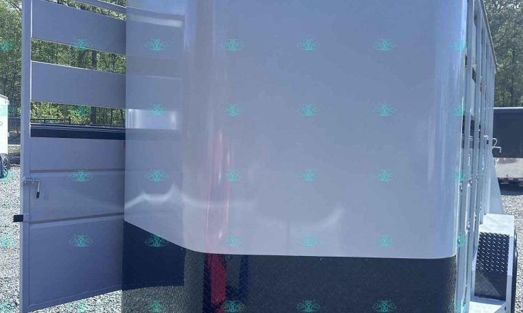 White Valley horse trailer with open side ramp parked on gravel, showing its diamond plate front and hitch with jack and safety chains.