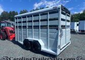 White livestock trailer with two axles and open side panels on a gravel lot, next to a red tractor, under a blue sky, branding reads Valley Trailers (CarolinaTrailerSales watermark).