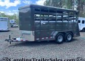Grey two-axle livestock trailer with slatted sides and diamond-plate front, parked on gravel (carrying branding for CarolinaTrailerSales.com).