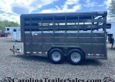 Two-axle black livestock trailer with open side slats and a gooseneck hitch, branding 'Valley Trailers', on a gravel lot