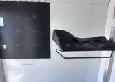 Interior of a trailer cargo area showing a black wall panel with multiple metal hooks and a curved black step seat mounted to the right side.