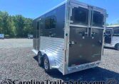 Silver Merhow horse trailer with double rear doors in a gravel lot, trees in the background