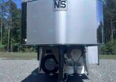 Industrial silver trailer front with NS (National Trailer Source) logo, parked on a gravel lot with trees and blue sky in the background
