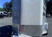 Front view of a white enclosed horse trailer with diamond-plate lower front, Valley Trailers logo, and hitch in a gravel lot.