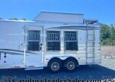 White horse trailer with barred windows and chrome wheels, parked on gravel under a clear blue sky.