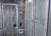 Interior of a travel trailer bathroom with gray cabinetry, a toilet, towel ring, and vented ceiling light.
