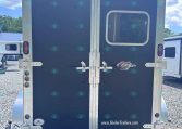 Rear view of a dark blue cargo trailer with silver framing and double doors; small window on right door and 'www.KieferTrailers.com' logo at bottom right.