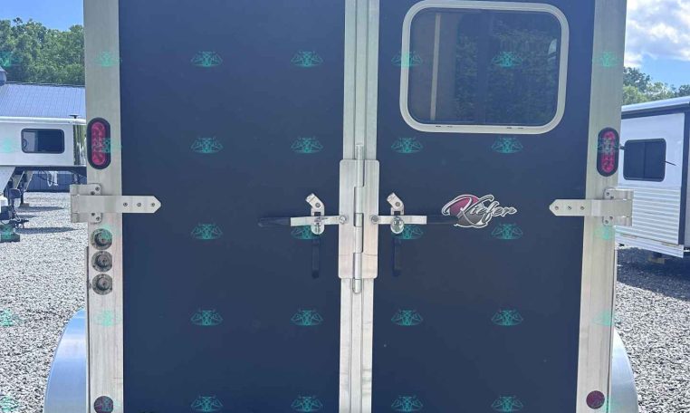 Rear view of a dark blue cargo trailer with silver framing and double doors; small window on right door and 'www.KieferTrailers.com' logo at bottom right.