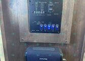 Metal outer panel with the word 'MERHOW' carved or engraved at the top, featuring a black control board with switches and indicators beneath it (likely a trailer or RV control panel). Inset readings show tank/level indicators and a toggle switch labeled 'START/STOP' nearby, plus a blue Alpine speaker mounted below.