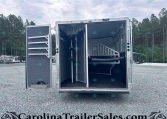 Open silver horse trailer with interior stalls and a ramp, parked on a gravel lot with trees in the background; watermark CarolinaTrailerSales.com at bottom.