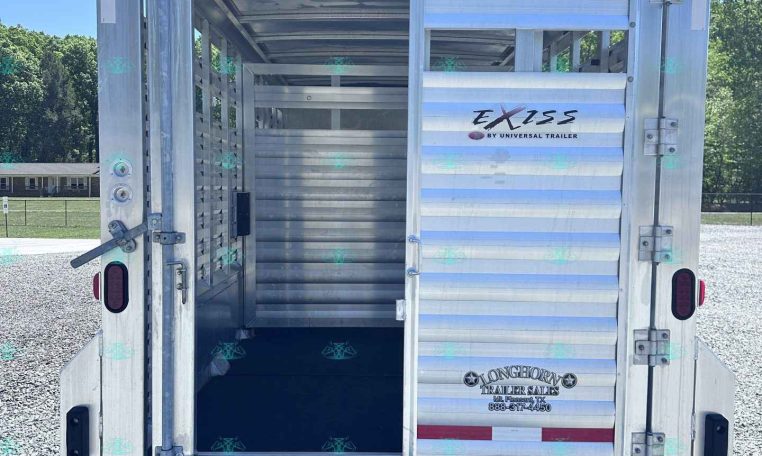 Rear view of an open aluminum livestock trailer with interior stalls and ramp, branded EXISS by Universal Trailer.