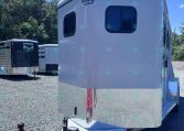 White travel trailer with rounded edges and diamond-plate front, parked on a gravel lot; Valley Trailers logo visible on the side.