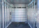 Interior of an aluminum trailer with ribbed walls and curved ceiling, showing a narrow aisle and side rails for securing cargo at CarolinaTrailerSales.com.