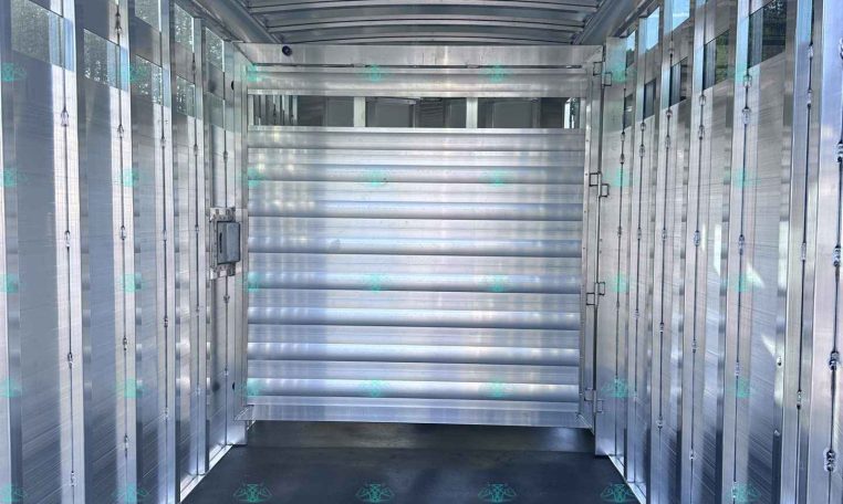 Interior of an aluminum trailer with ribbed walls and curved ceiling, showing a narrow aisle and side rails for securing cargo at CarolinaTrailerSales.com.