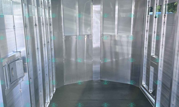 Inside an empty aluminum cargo trailer with ribbed ceiling and smooth metal walls ready for loading