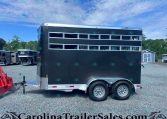 Black stock trailer with horizontal screened vents, tandem wheels, parked on gravel lot; watermark CarolinaTrailersales.com visible in foreground.