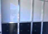 Interior of a metal-framed trailer wall with vertical studs and glossy gray panels along the sides, plus a row of hooks near the ceiling