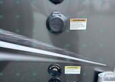 Back of a utility trailer showing a fuel/ electrical hookup caps and a city water connection panel with caution labels (carolinaTrailerSales.com text visible).