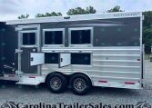 Merhow horse trailer with three open side storage compartments and windows on a gray aluminum body.