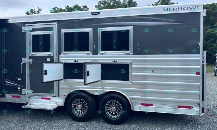 Merhow horse trailer with three open side storage compartments and windows on a gray aluminum body.