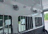 Side view of a gray horse trailer with barred windows and mounted fans on the exterior ceiling area