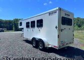 White Shadow Select horse trailer parked on a gravel lot under a clear blue sky.